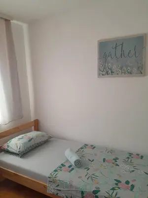 a bed in a bedroom with a sign on the wall at Apartment Ken 1 in Surčin