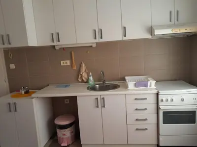 a kitchen with white cabinets and a sink and a stove at Apartment Ken 1 in Surčin