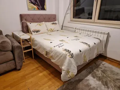 a bedroom with a bed and a chair and a couch at Owl Apartment in Belgrade
