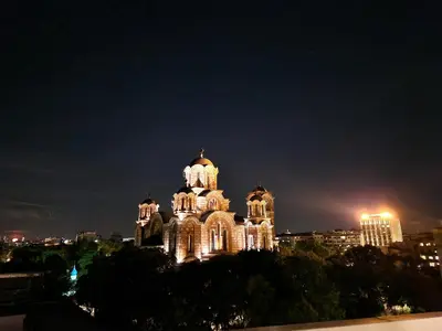 a large building with lights on it at night at Owl Apartment in Belgrade