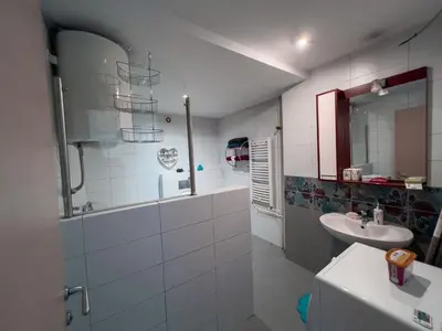 a white bathroom with a sink and a mirror at Owl Apartment in Belgrade