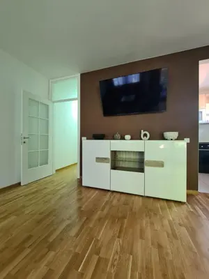 a living room with a white cabinet with a tv at Friend LUX Apartman Beograd in Belgrade
