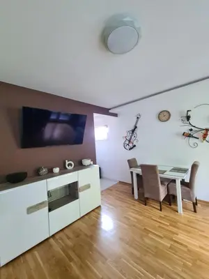 a living room with a dining table and a tv at Friend LUX Apartman Beograd in Belgrade