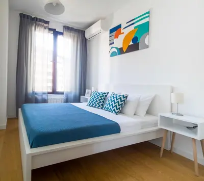a white bedroom with a bed and a window at Belgrade Riverfront Fortress Apartment in Belgrade