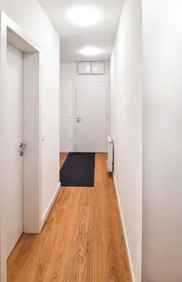an empty hallway with a door and a wooden floor at Belgrade Riverfront Fortress Apartment in Belgrade