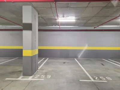 an empty parking garage with a yellow and white wall at Belgrade Riverfront Fortress Apartment in Belgrade