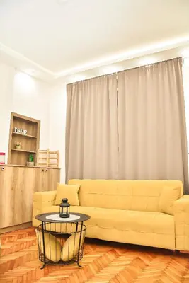 a living room with a yellow couch and a table at Hedonist-Belgrade Central Nest in Belgrade