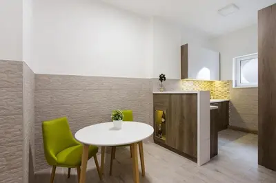 a dining room with a table and green chairs at Hedonist-Belgrade Central Nest in Belgrade