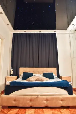 a bedroom with a large bed with blue sheets at Hedonist-Belgrade Central Nest in Belgrade