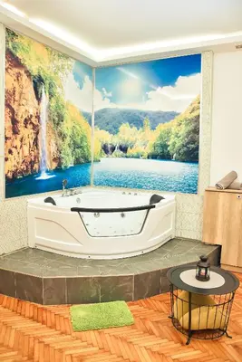 a bathtub in a room with a waterfall mural at Hedonist-Belgrade Central Nest in Belgrade