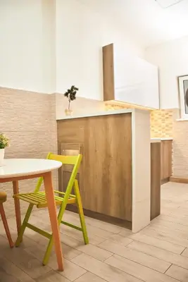 a kitchen with a table and a yellow chair at Hedonist-Belgrade Central Nest in Belgrade