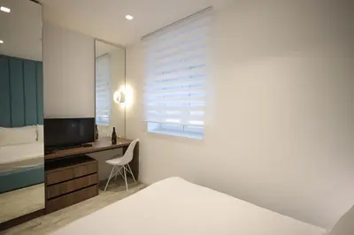 a bedroom with a bed and a desk with a television at Royal Wellness and Spa in Ruma