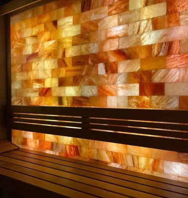 a brick wall behind a bench in a room at Royal Wellness and Spa in Ruma