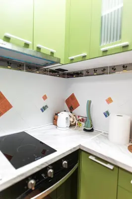a kitchen with green cabinets and a stove top oven at Ugi house - City Center in Belgrade
