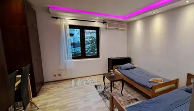 a room with a bed and a table and a window at Quiet place near the city center in Sajmište