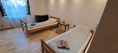 a room with two beds and a chair in it at Quiet place near the city center in Sajmište