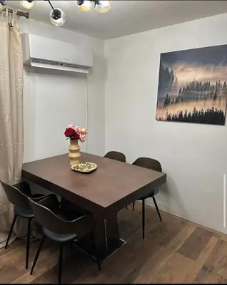 a dining room table with chairs and a painting on the wall at Mila Vila Fruška Gora in Irig