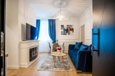 a living room with a blue couch and a table at Apartman Provance in Batajnica