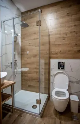 a bathroom with a toilet and a glass shower at Apartman Provance in Batajnica