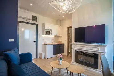 a living room with a blue couch and a fireplace at Apartman Provance in Batajnica