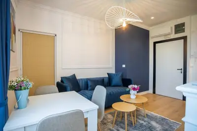 a living room with a blue couch and a table at Apartman Provance in Batajnica