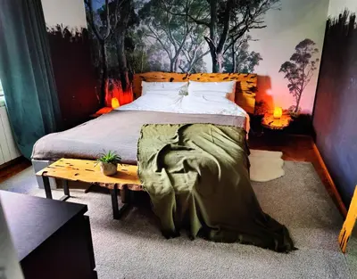 a bedroom with a bed and a table with lights at Hedonists Paradise in Omoljica