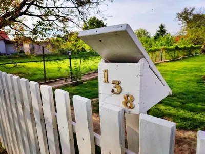 a white fence with a white mailbox on it at Hedonists Paradise in Omoljica