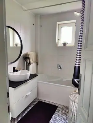 a bathroom with a tub and a sink and a mirror at Hedonists Paradise in Omoljica