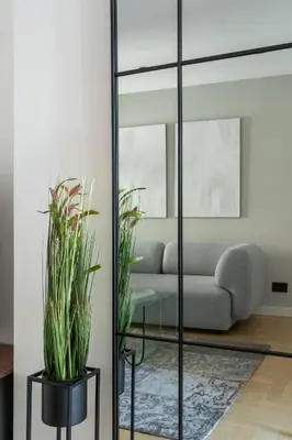a living room with a couch and a mirror at HostGost Selected Suites – Parliament in Belgrade