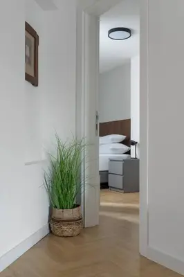 a white room with a plant in a basket at HostGost Selected Suites – Parliament in Belgrade
