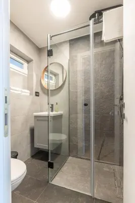 a bathroom with a glass shower with a toilet at HostGost Selected Suites – Parliament in Belgrade