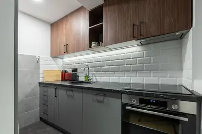 a kitchen with stainless steel appliances and wooden cabinets at HostGost Selected Suites – Parliament in Belgrade