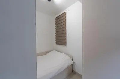 a small bedroom with white walls and a window at Comanda LUXURY APARTMENTS in Belgrade