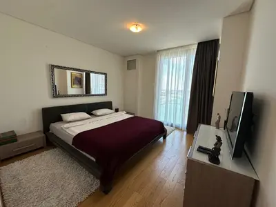 a bedroom with a bed and a flat screen tv at Queen BW in Sajmište