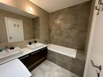 a bathroom with a sink and a tub and a mirror at Queen BW in Sajmište