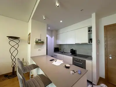 a kitchen with a table and chairs and a counter at Queen BW in Sajmište