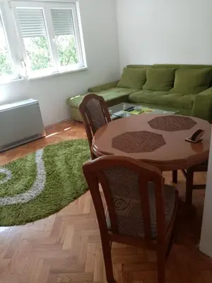 a living room with a table and a green couch at Martin in Belgrade