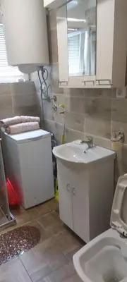 a bathroom with a sink and a toilet and a mirror at Martin in Belgrade