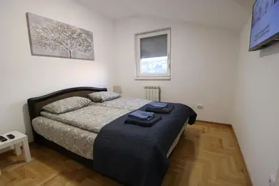 a bedroom with a bed in a white room at Flat 23 in Belgrade