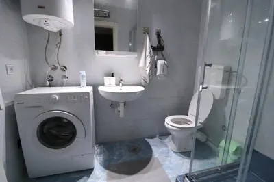 a bathroom with a washing machine and a sink at Flat 23 in Belgrade