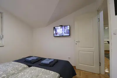 a bedroom with a bed and a tv on the wall at Flat 23 in Belgrade