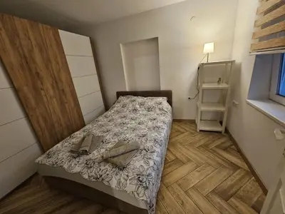 a small bedroom with a bed and a wooden floor at Apartment Pegy in Novi Grad