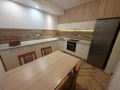 a kitchen with a wooden table and a refrigerator at Apartment Pegy in Novi Grad