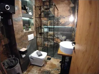 a bathroom with a toilet and a sink and a shower at Maximilian apartman in Smederevo