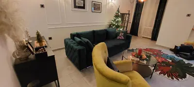 a living room with a green couch and a christmas tree at Maximilian apartman in Smederevo
