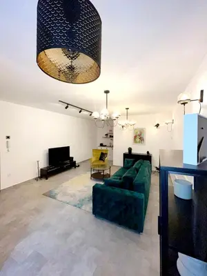 a living room with a green couch and a piano at Maximilian apartman in Smederevo