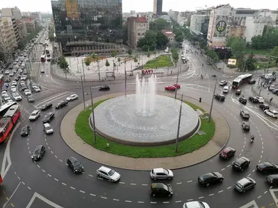 a city with a fountain in the middle of a street at Apartman Tara in Belgrade