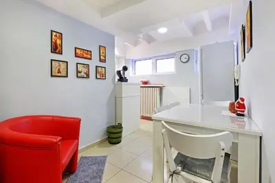 a living room with a red chair and a desk at Apartman Tara in Belgrade