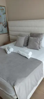 a large bed with white sheets and pillows at BW VERDE LUX in Sajmište