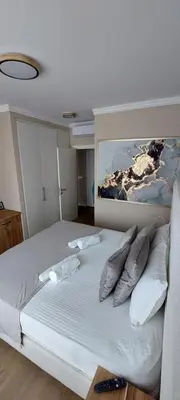 a bedroom with a white bed with a painting on the wall at BW VERDE LUX in Sajmište